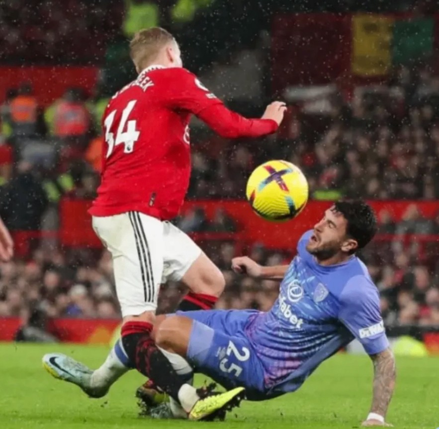 Footballer making a sliding tackle, a common cause of knee ligament injuries